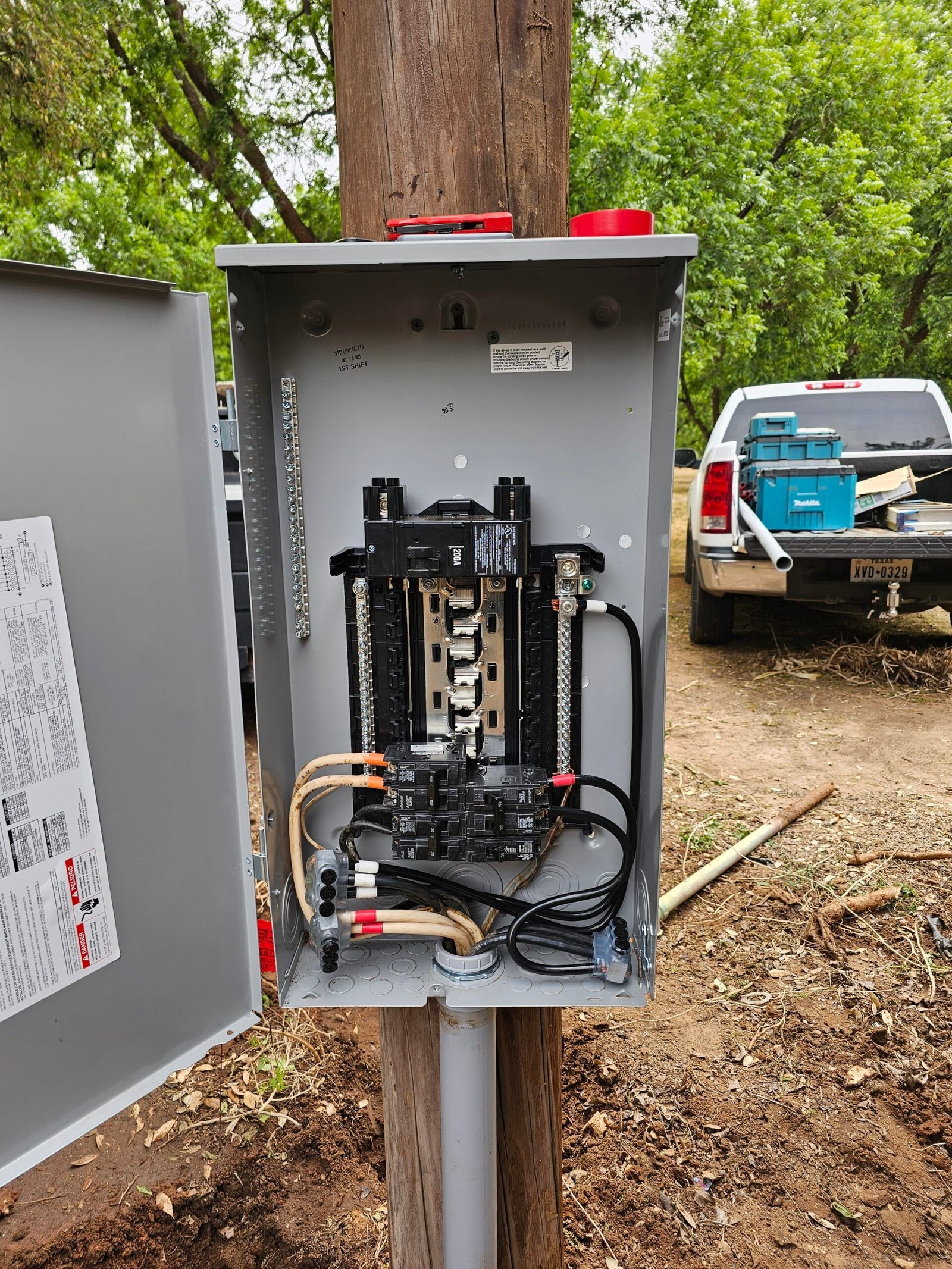 200-amp electrical service panel being installed on a rural job site